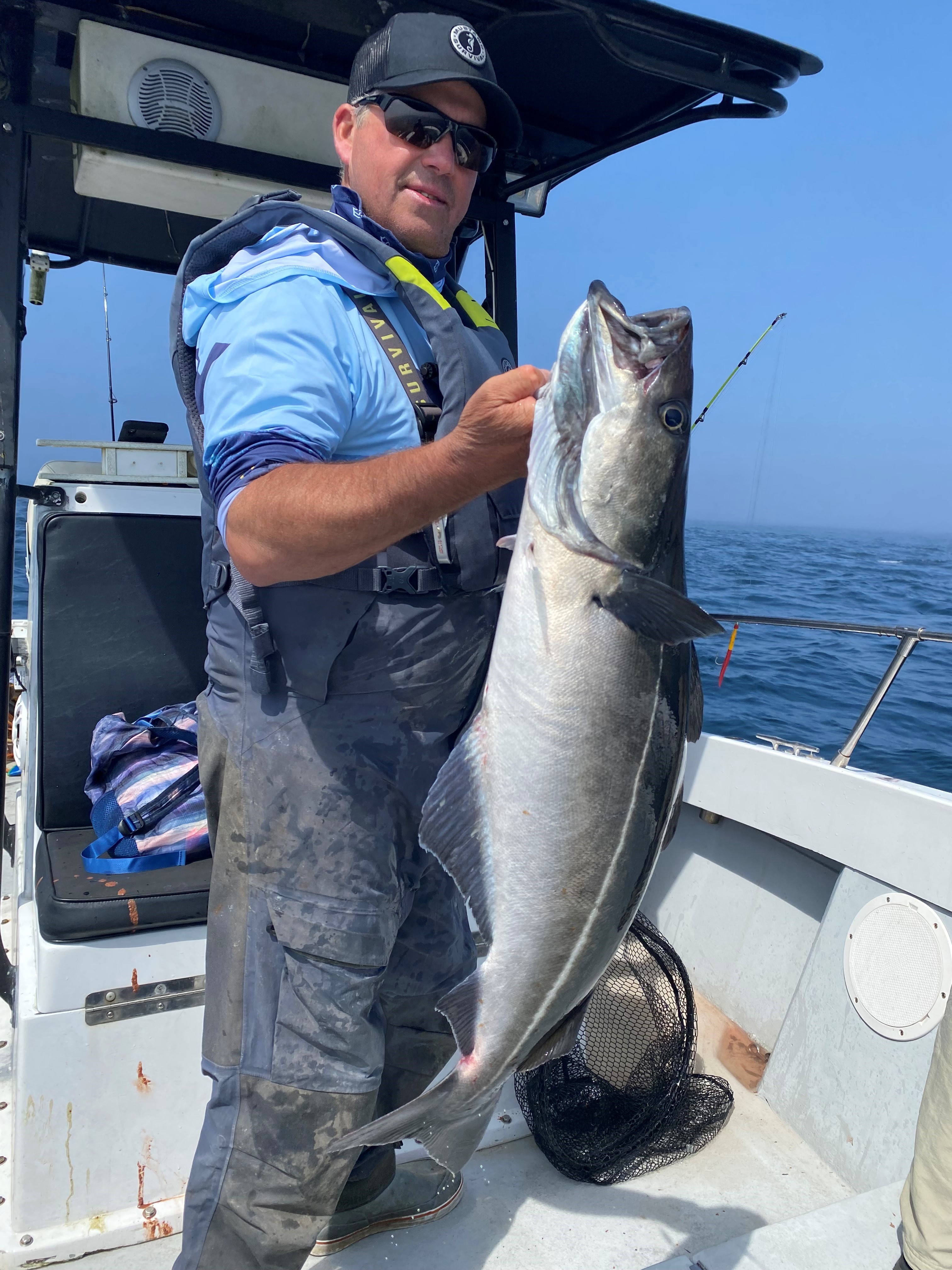 Man on boat holding big fish